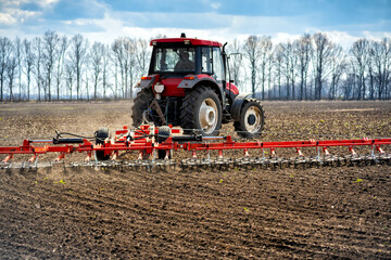 Obraz premium tillage in the field with a tractor with a trailed machine