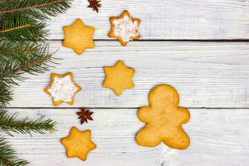 Christmas flat lay. Christmas cookies and fir branches on white wooden boards.