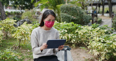 Woman wear face mask and use of tablet computer at pandemic period