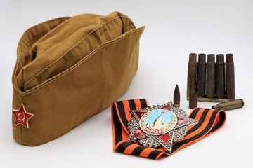 Military cap with a red star, the order of Victory on the St. George ribbon and cartridge cases on...