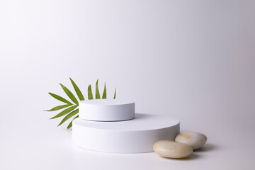 White podium on the white background with tropical leaf. Podium for product, cosmetic presentation....