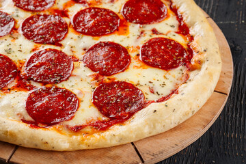 Fresh baked pepeproni pizza on the wooden background