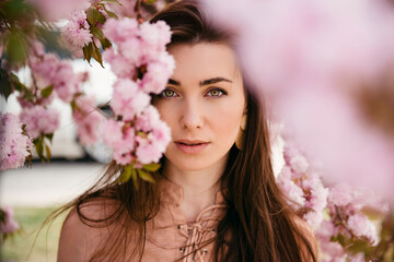 Girl face portrait under blossom sakura flowers