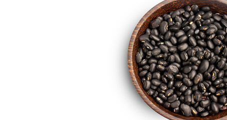 Black beans in wooden bowl on white background, top view, copy space