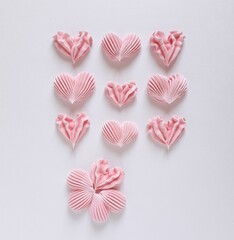Pink meringue hearts on a white background. Meringue kisses. French dessert. - obrazy, fototapety, plakaty