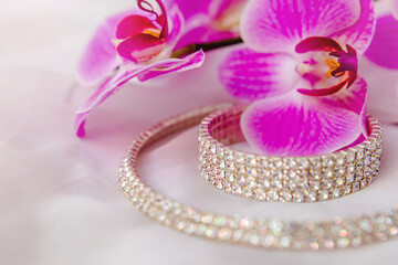 Bracelet and necklace on white fabric and purple Orchid
