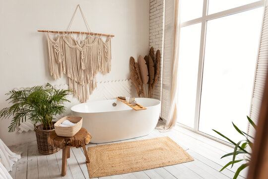 Cozy modern minimalistic bathroom interior with big white bathtube indoors