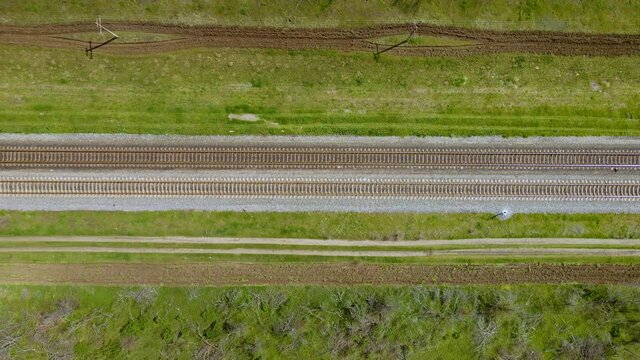 Railway with rails and sleepers for two side traffic between country roads. Way safety and cargo transportation concept