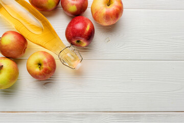 A bottle of apple cider vinegar or juice with apples on a white background with copy space.