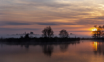 Fototapeta na wymiar Orange Sunrise with reflections on the water