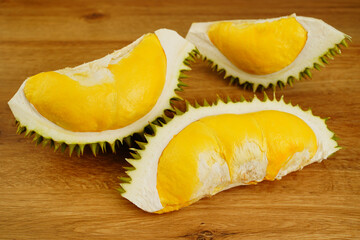 Closeup durian fruit peel in half on wooden table background. A smelly tropical seasonal fruit of Asia. The most tasty king fruit very popular in Thailand due to its freshness, sweet and delicious.