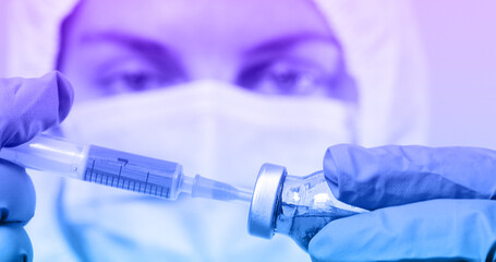Doctor in blue latex gloves fill first dose in syringe with covid-19 vaccine medicine from glass vial for injection of elderly person in medical laboratory against coronavirus, flu, measles disease