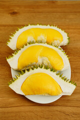 Closeup durian fruit peel in half on wooden table background. A smelly tropical seasonal fruit of Asia. The most tasty king fruit very popular in Thailand due to its freshness, sweet and delicious.
