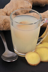 Infusion de gingembre frais dans un mug en gros plan sur fond noir