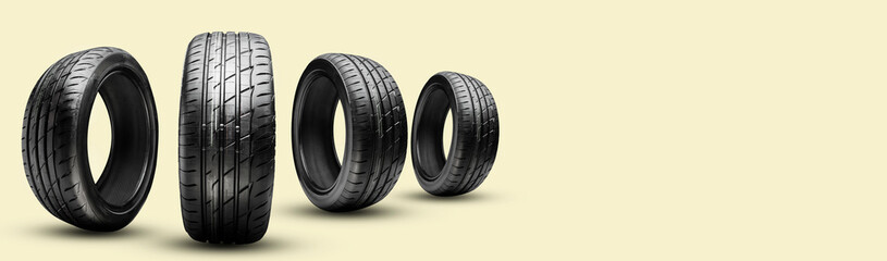 four summer tires on a yellow background, long panoramic copy space concept © Vladimir Razgulyaev