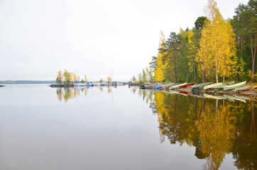 Beautiful reflection of boas and autumn forest on the lake, close to sauna of Rauhaniemi, Tampere, Finland