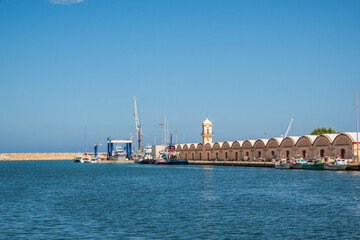 Fototapeta na wymiar Views of the port of Gandia, with the sheds, warehouses and the fish market., on a sunny day.