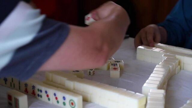 Chinese people play mahjong, or majiang, an asian tile-based game.