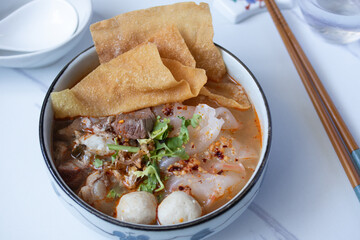 big flat noodles with pork and meatballs tom yum