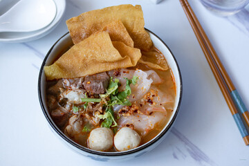 big flat noodles with pork and meatballs tom yum