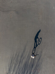 Long shadow of a man on a bicycle on the asphalt. Street sport concept