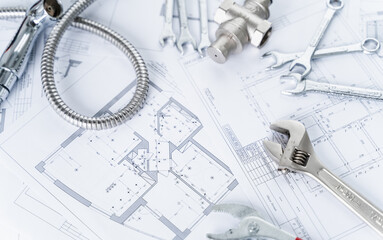 Plumbing project in house.Drawing,diagrams,plan of water supply of apartment,building.Man repairer making repairs at home.Devices,accessories, hose,tap,adjustable wrench,pressure reducer,tape measure