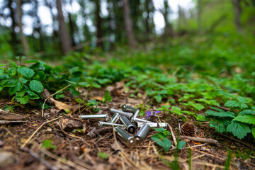 Exhausted batteries thrown in the grass, in a wood. Ecology and environmental protection. Disposal of polluting waste.