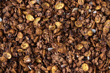 Organic homemade roasted granola cereal with oats, flax, almonds, chocolate and sunflower seeds. Top view muesli background texture