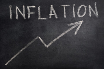 the inflation very high. symbol of an up arrow and the word inflation written in chalk on a...