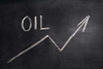 the oil price is very high. simbol of an up arrow and the word oil written on a blackboard
