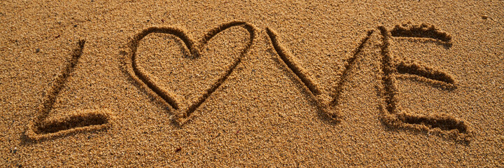 The word Love written on the sand of the beach