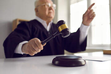 Senior man of law pronounces sentence in court. Mature judge finds the accused guilty, passes fair...