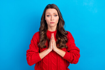 Portrait of attractive girlish girl pleading forgiveness isolated over vibrant blue color background
