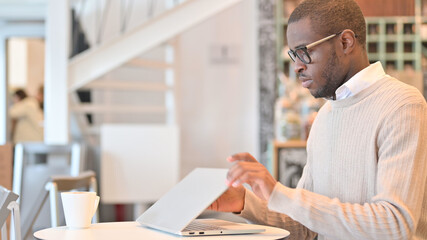 Obraz premium Professional African Man Opening Laptop for Work