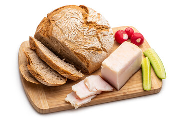 Rustic food. Loaf of bread, sliced bacon, fresh cucumbers and radishes on wooden board