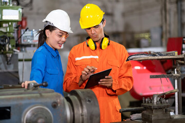 Engineer worker inspect the rolling machine in the factory with colleague. Woman see checklist from tablet. Preventive maintenance in factory. Industrial, technology and innovation concept.