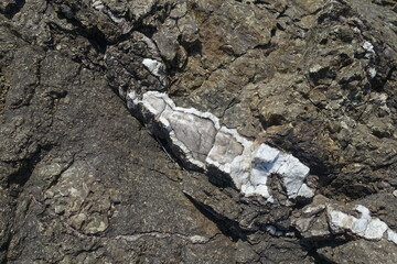 Quartz vein. Rock-forming minerals in the composition of rock. The texture of natural stone.