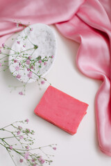 Spa composition with pink soap bar with ceramic soap dish, silk babric and flowers