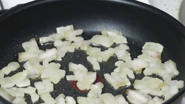 Pieces of lard are fried in a pan.