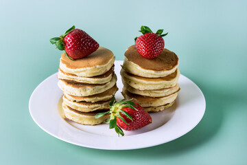 Freshly Baked Homemade Mini Pancakes on a Plate Fresh Berry Tasty Breakfast Green Background Horizontal