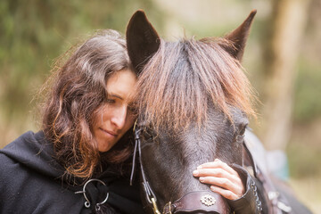 Fototapeta premium woman in historical costume as a warrior hugs his horse