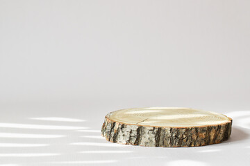 A wooden stage for the presentation of eco-friendly products. The podium is made of natural material with space for text. A minimalistic scene of a natural product for branding.