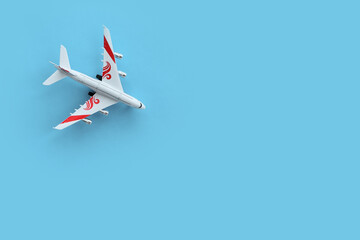 Model of a toy airplane of white color on a blue background