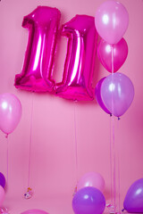 colorful blue, pink and purple balloons near air balloons shaped number eleven . on pink...