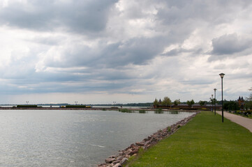 Fototapeta na wymiar Panoramic view of the embankment with green lawns and the calm surface of Lake Balaton.