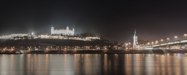Fototapeta na wymiar Historical Bratislava above Danube river, the bridge; Bratislava at night, Slovakia; High-quality long exposure nigh photography with latest canon R camera, 