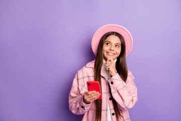 Portrait of attractive cheerful curious girl using gadget creating new post smm copy space isolated over bright violet purple color background