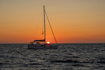 Orange Sunset Santorini  from a Tourist Cruise boat, trip for Aegean Sea 