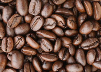 pile of brown roasted coffee beans close-up
