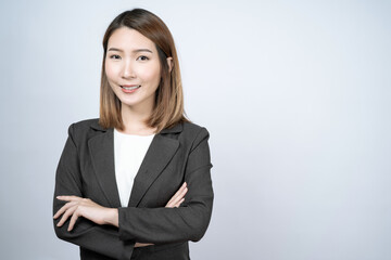 Beautiful Asian businesswoman in a black suit, isolated on a white background.